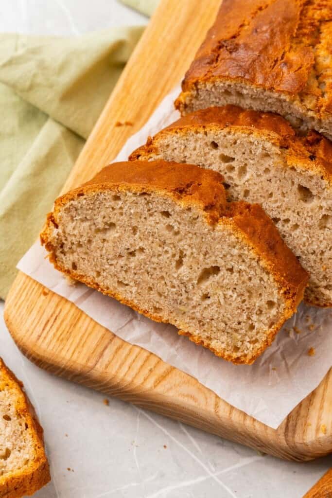 Sliced banana bread on a wooden cutting board.