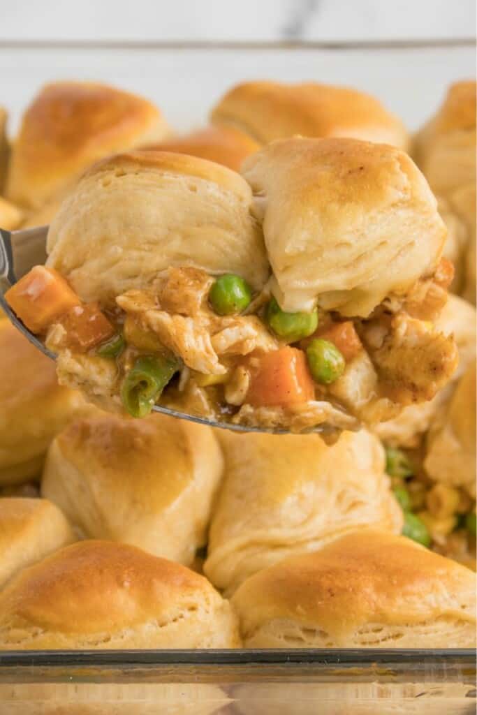 A close up view of a bite of biscuit topped chicken pot pie.