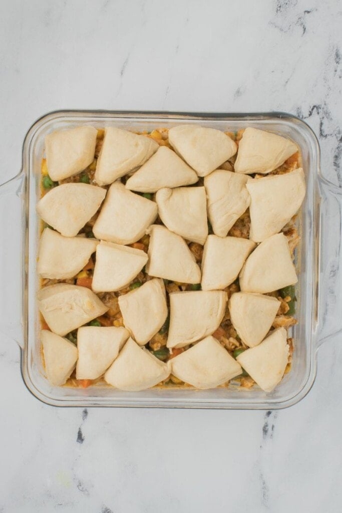 Cutting the biscuits into smaller pieces to top the chicken pot pie filling.