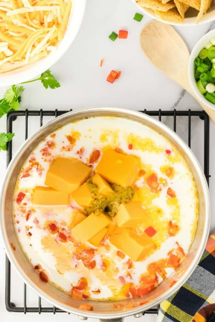 melting down velveeta cheese with peppers and milk