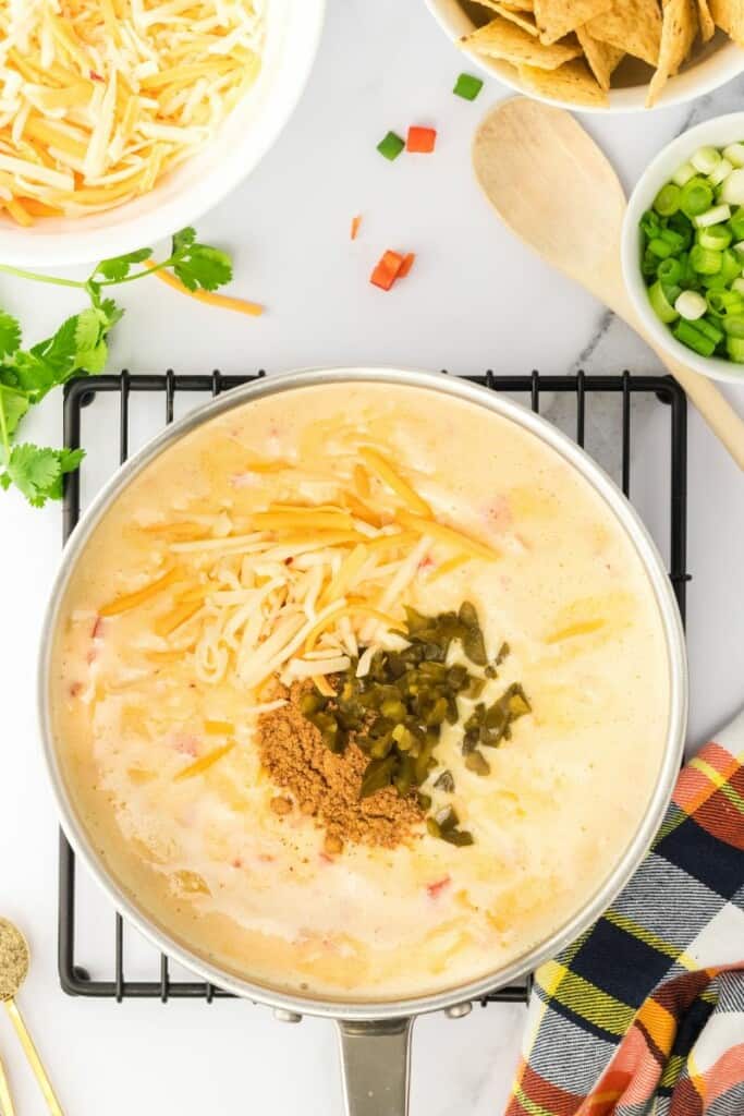 adding in taco seasoning to cheesy sauce