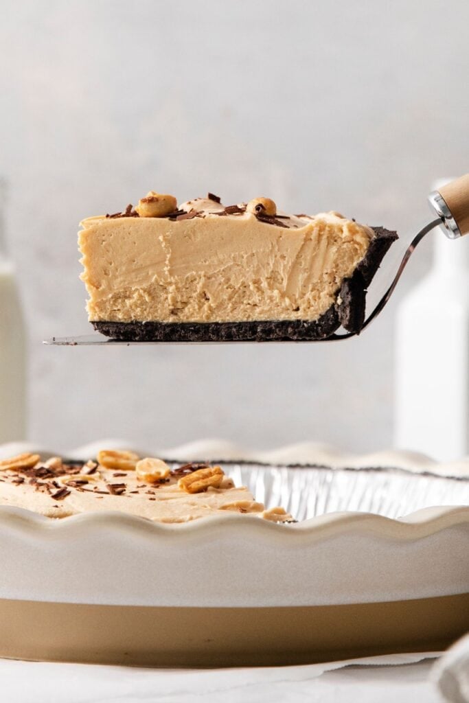 A piece of the easy peanut butter pie recipe being lifted up to see the inside.