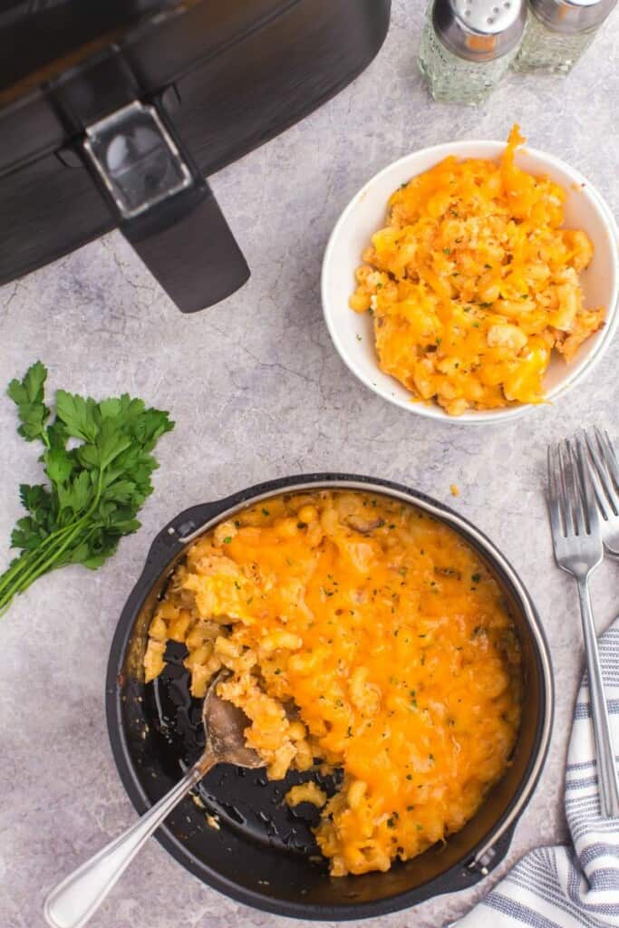 overhead shot of serving macaroni and cheese in a bowl with a spoon.