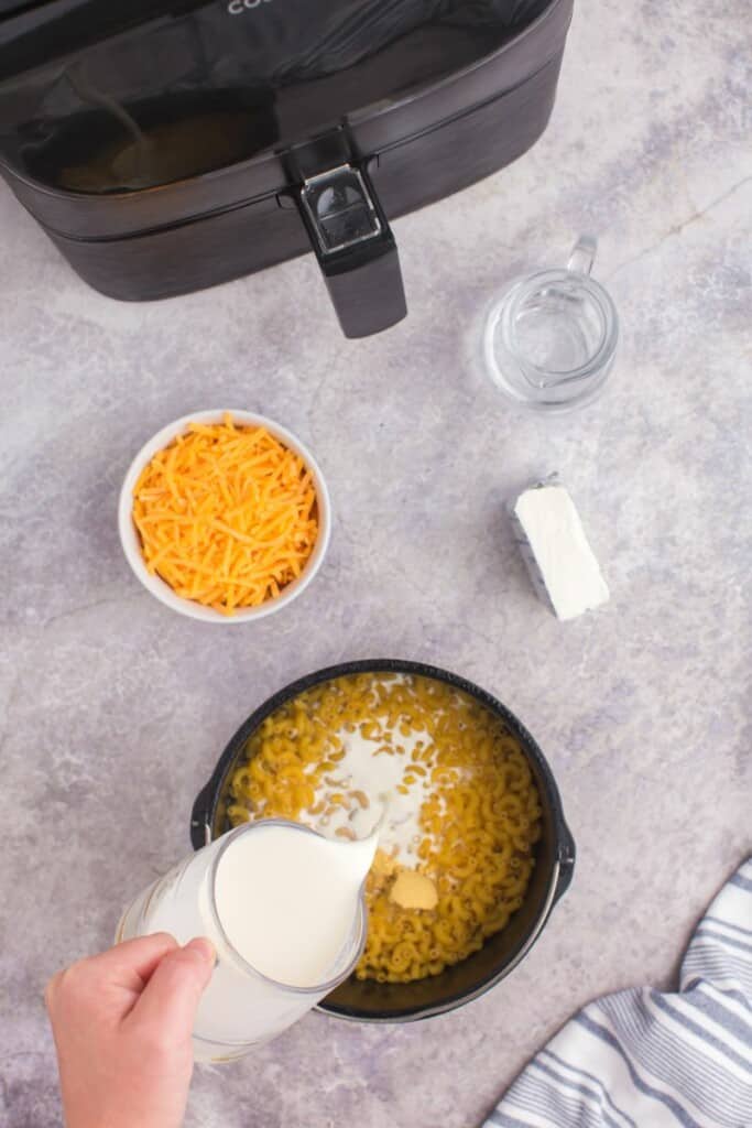 adding in heavy cream to dry noodles.