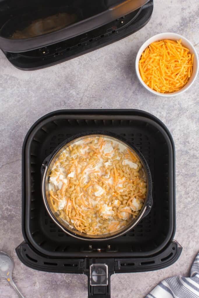 stirring all of the mac and cheese ingredients in a pot.