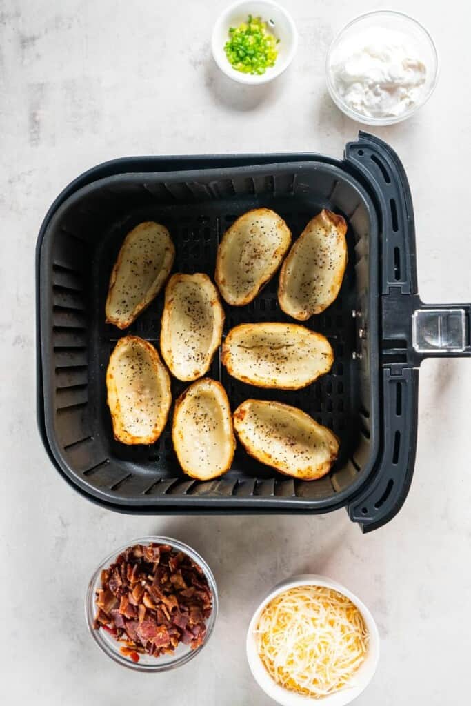 baking potato halves in the air fryer basket.