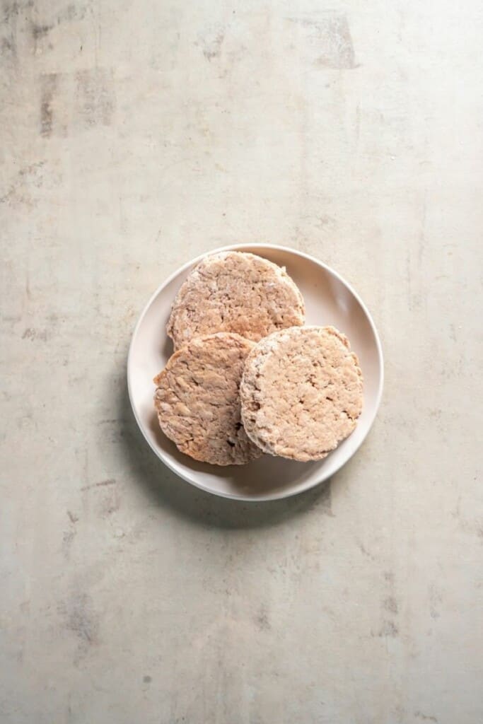 frozen turkey burgers on a white plate.