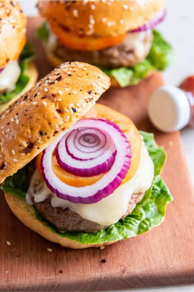 a cooked frozen turkey burger in a bun with cheese and toppings.