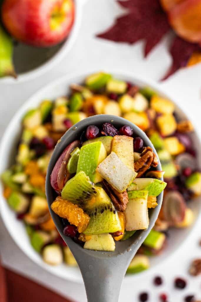 using a slotted spoon to serve fruit salad at Thanksgiving.