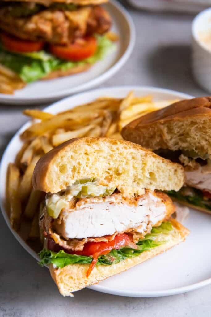 air fried chicken sandwich cut in half with fries