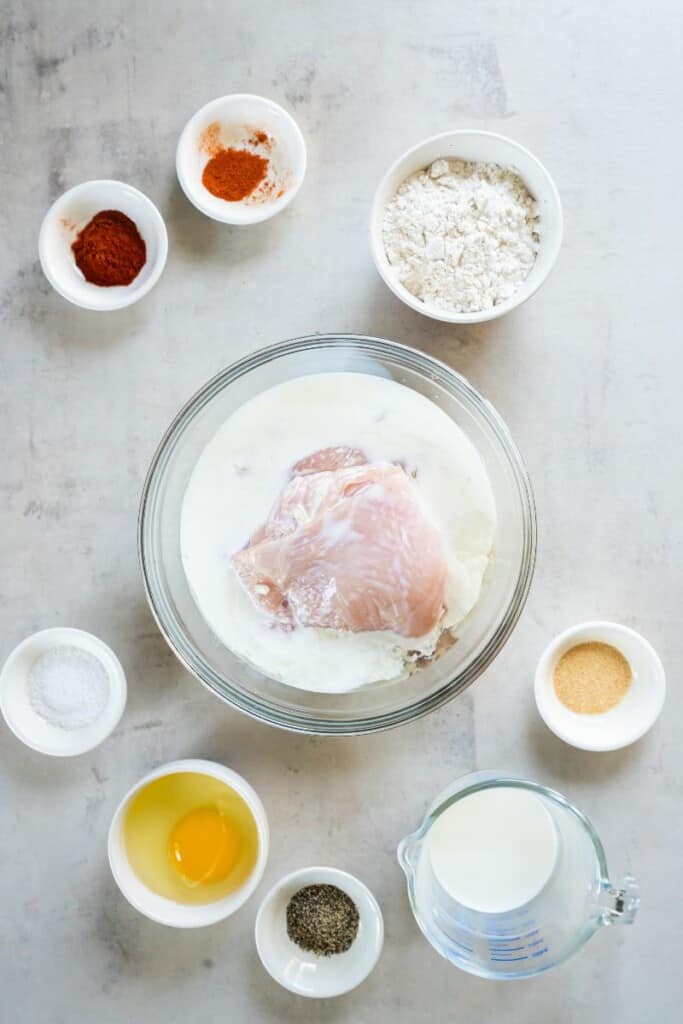raw chicken in a bowl with buttermilk and pickle juice