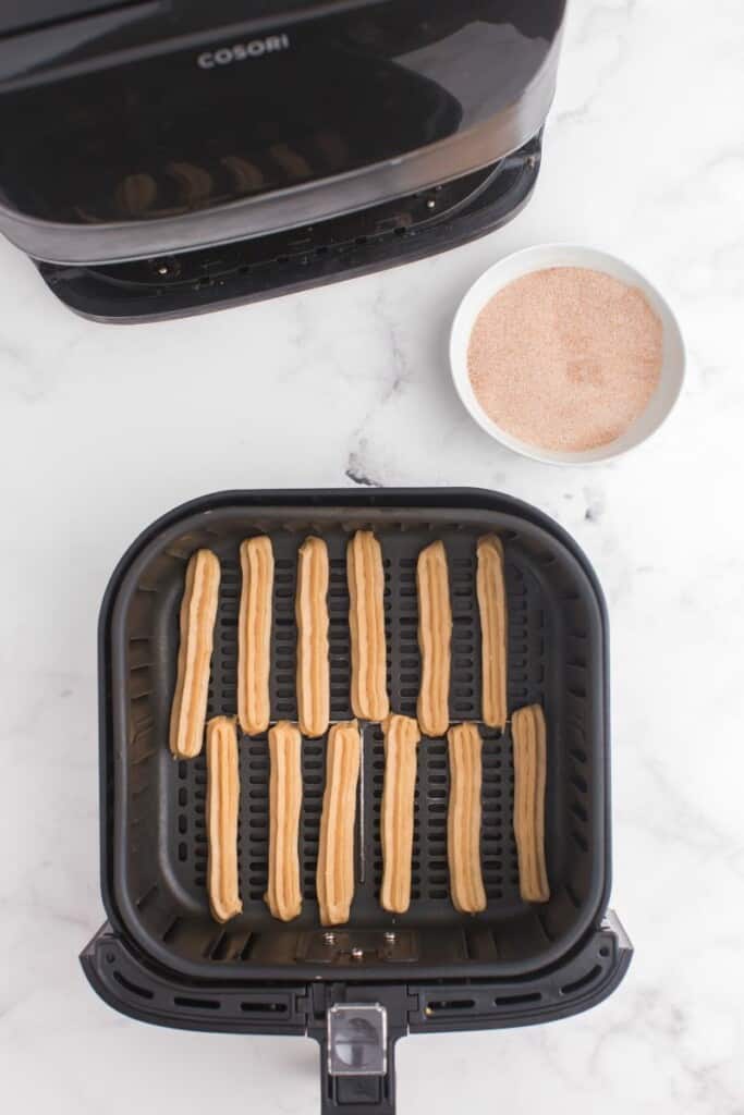 adding chilled raw churros to air fryer basket