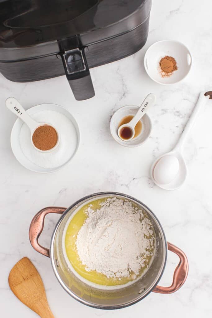 adding flour to melted butter and sugar in a pot