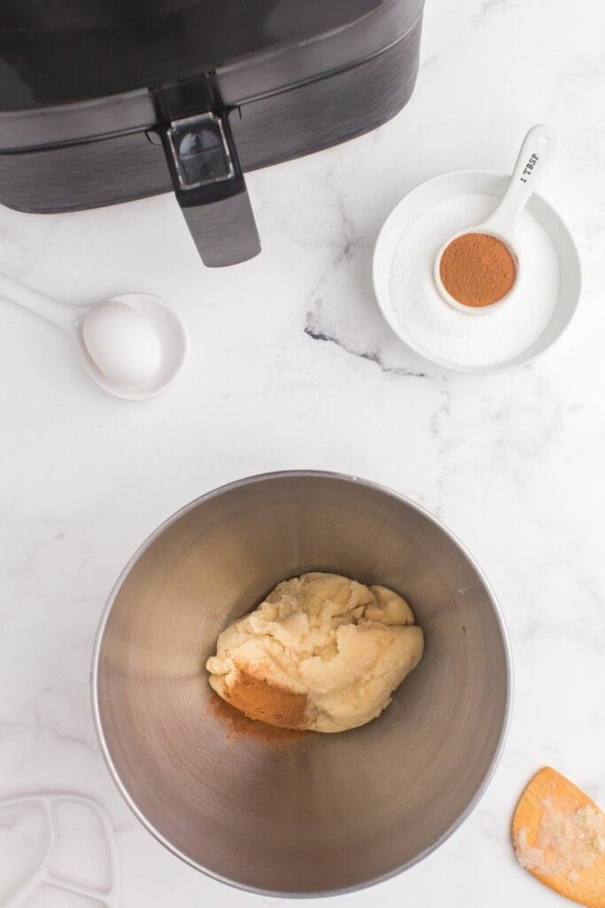 adding cinnamon and vanilla to churro dough