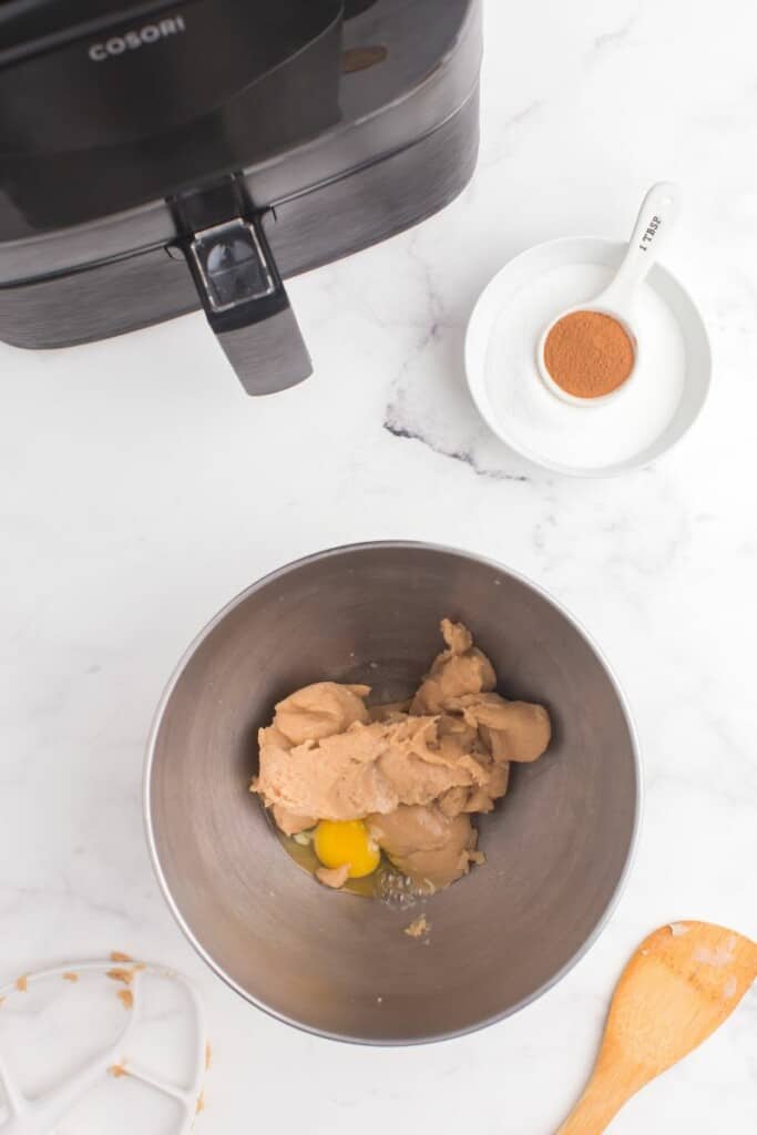 adding eggs to cinnamon churro dough