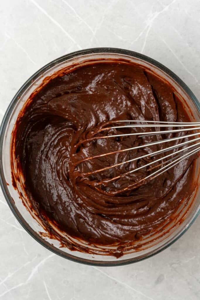 Adding milk and vanilla extract to chocolate pudding mix.
