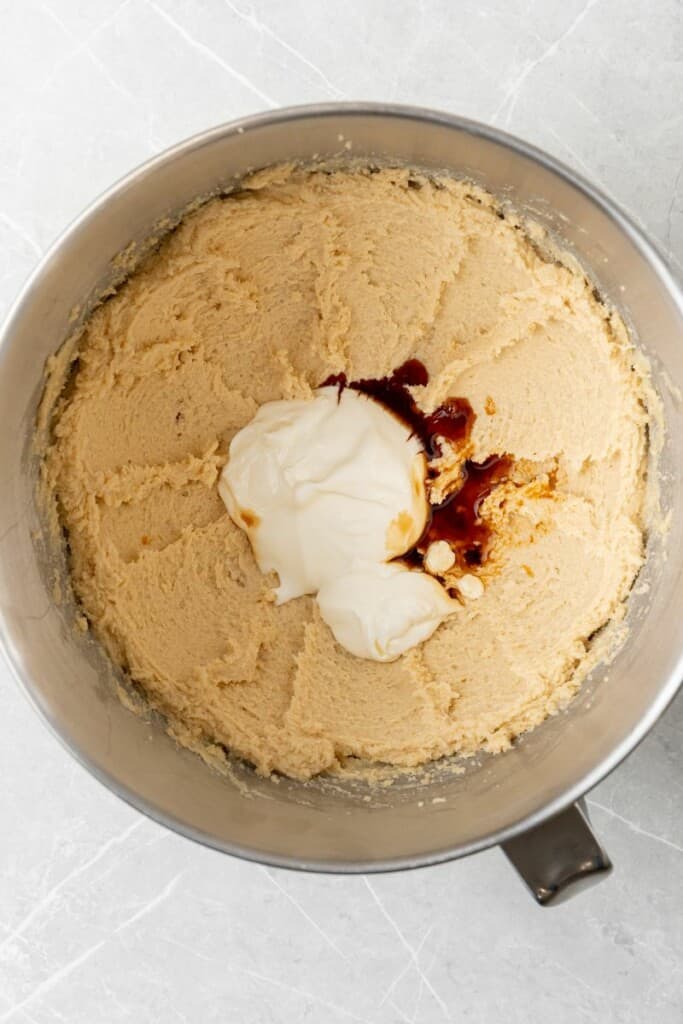 adding vanilla and sour cream to whipped sugar and butter