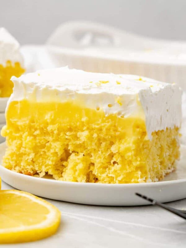 a slice of lemon poke cake on a white plate