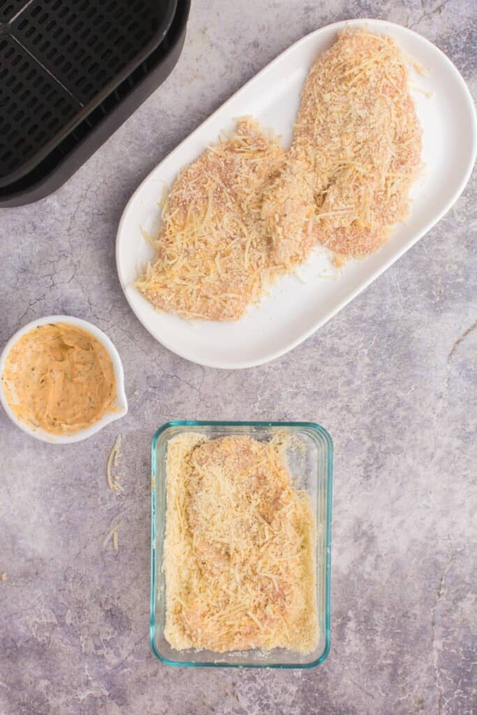 coating chicken breast with shredded parmesan cheese