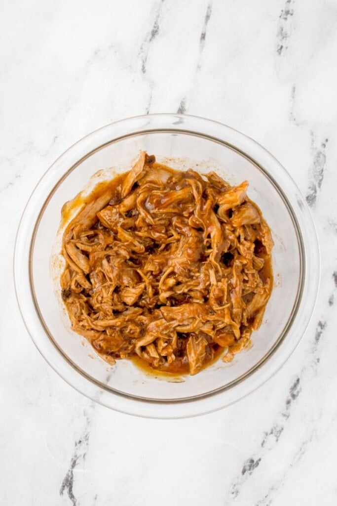 mixing bbq sauce into leftover pulled pork