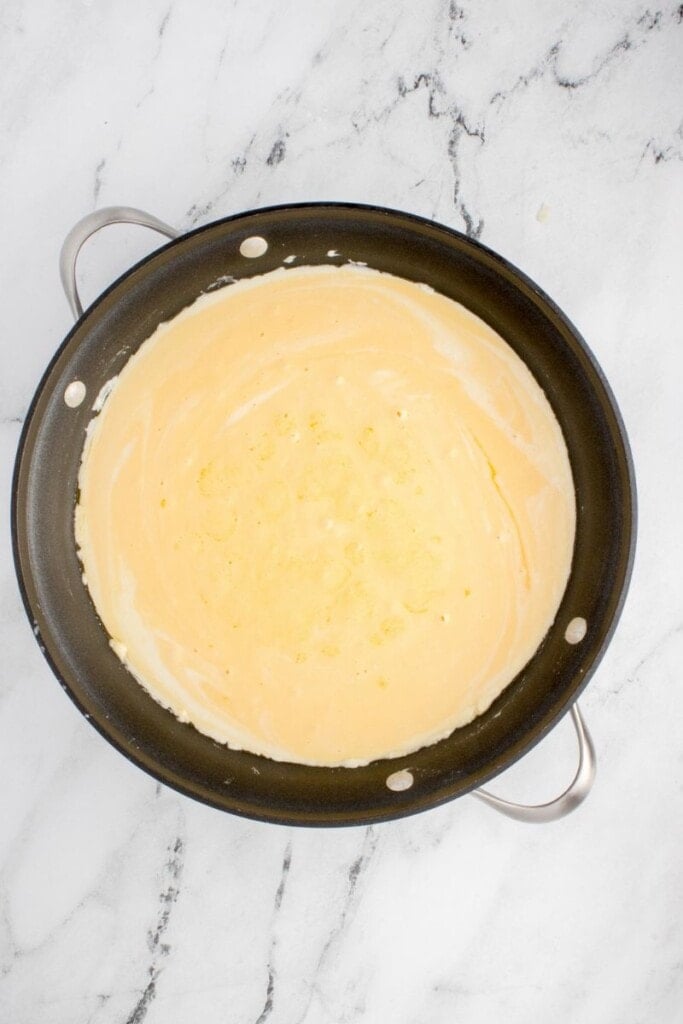 creamy mac and cheese sauce in a hot pan
