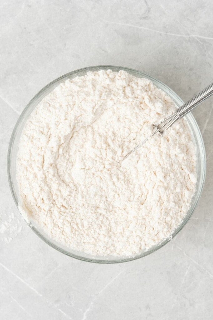 mixing together all of the flour and baking soda in a bowl