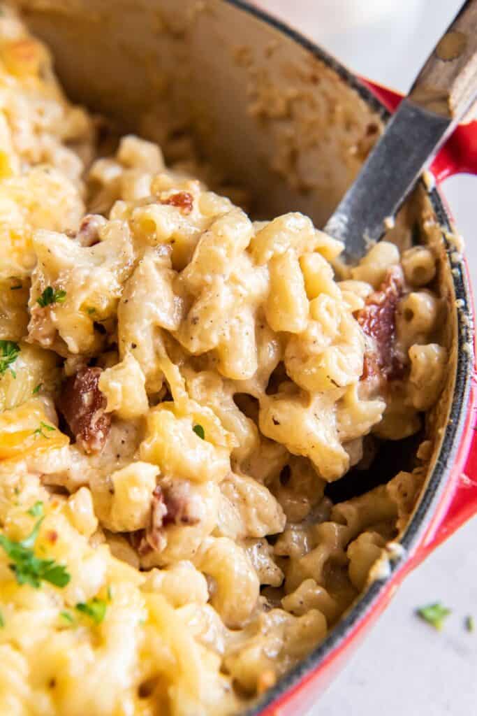 Close up of the dutch oven mac and cheese being scooped up with a serving spoon.
