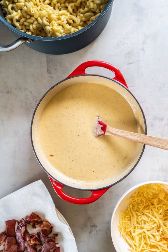 The cheese sauce in a dutch oven for the bacon mac and cheese recipe.