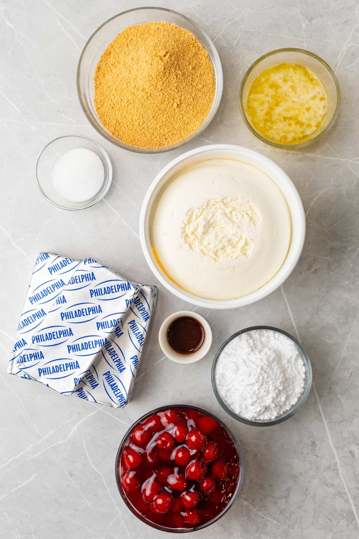 Ingredients needed to make this no bake cheesecake recipe: graham crackers, butter, sugar, powdered sugar, cream cheese, vanilla, Cool Whip, and cherry pie filling.