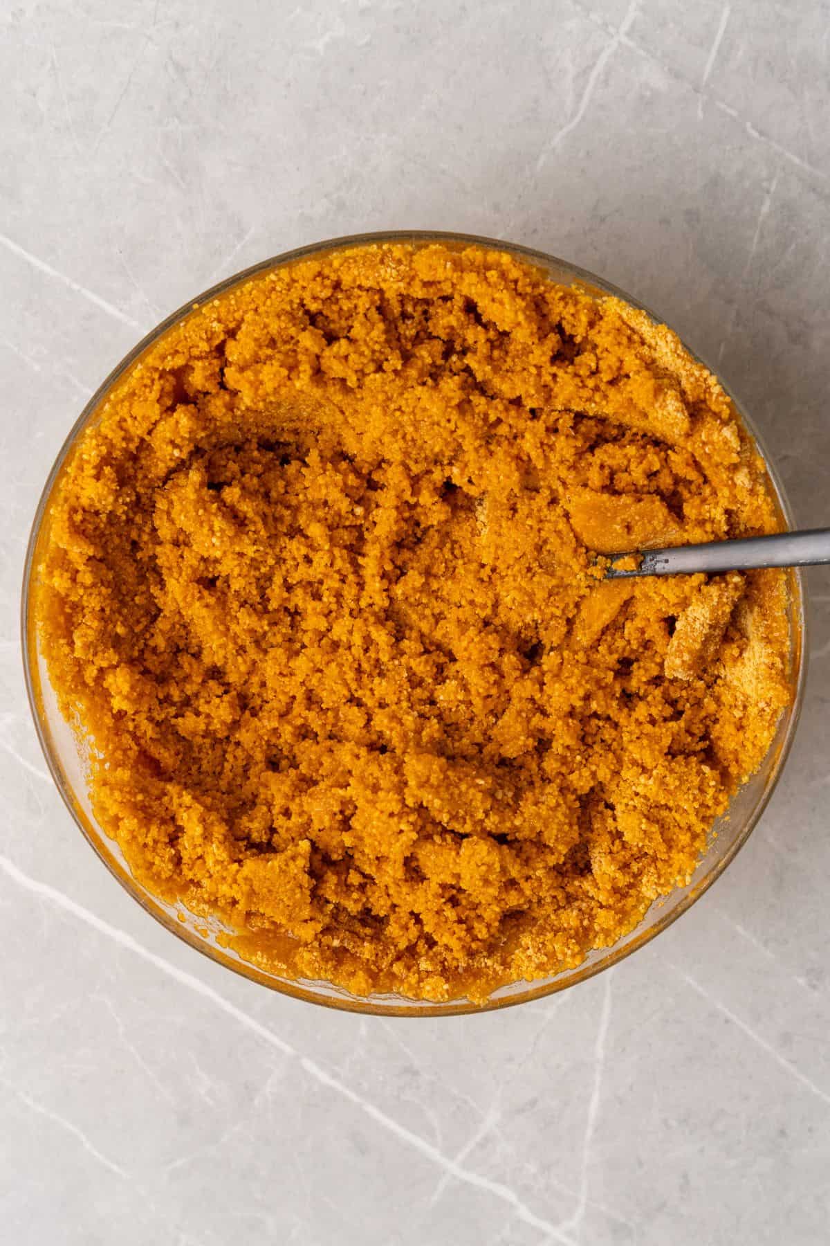 Graham cracker crumbs, butter, and sugar mixed in a bowl.
