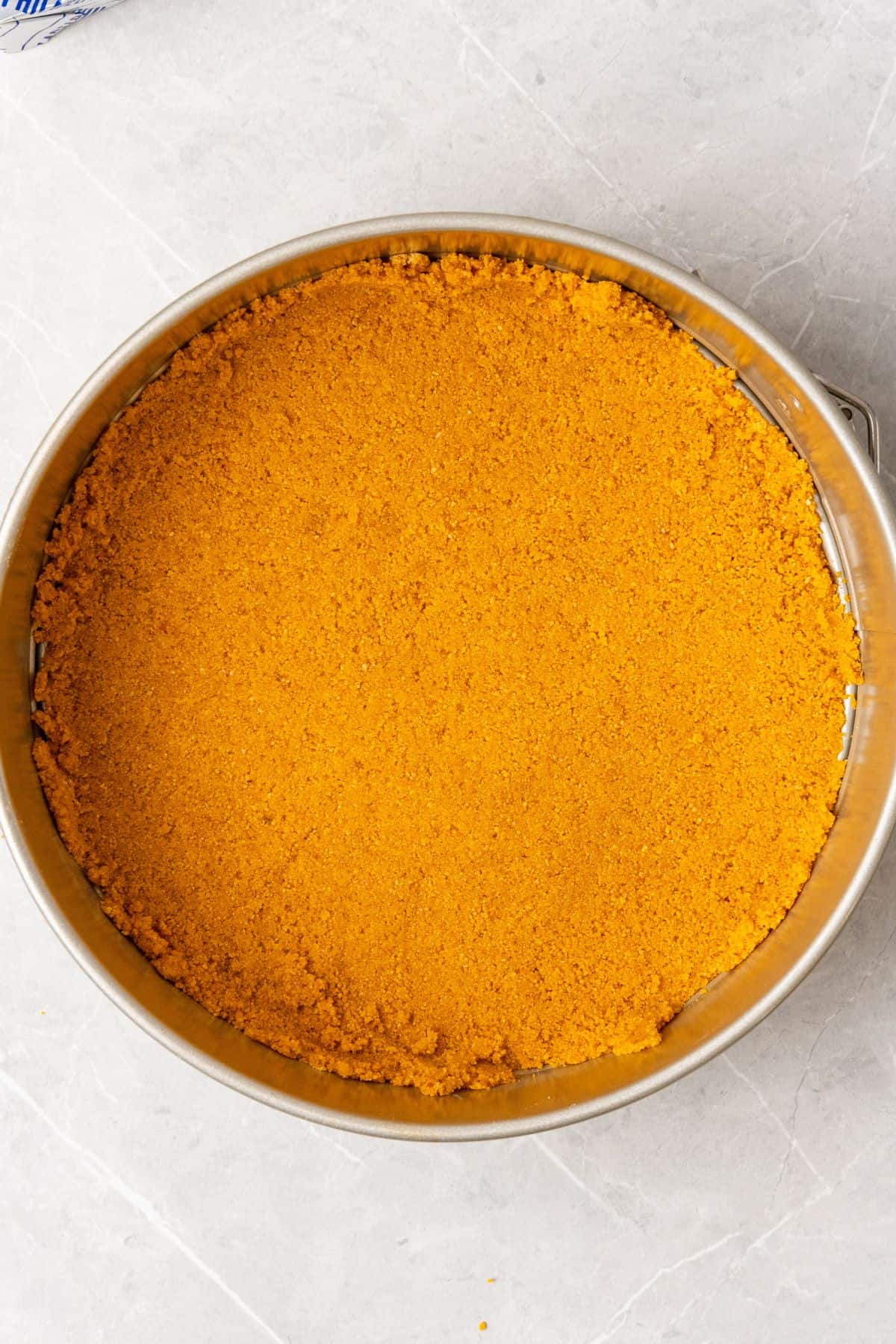 Graham cracker crust pressed into a springform pan to make the no bake cheesecake.