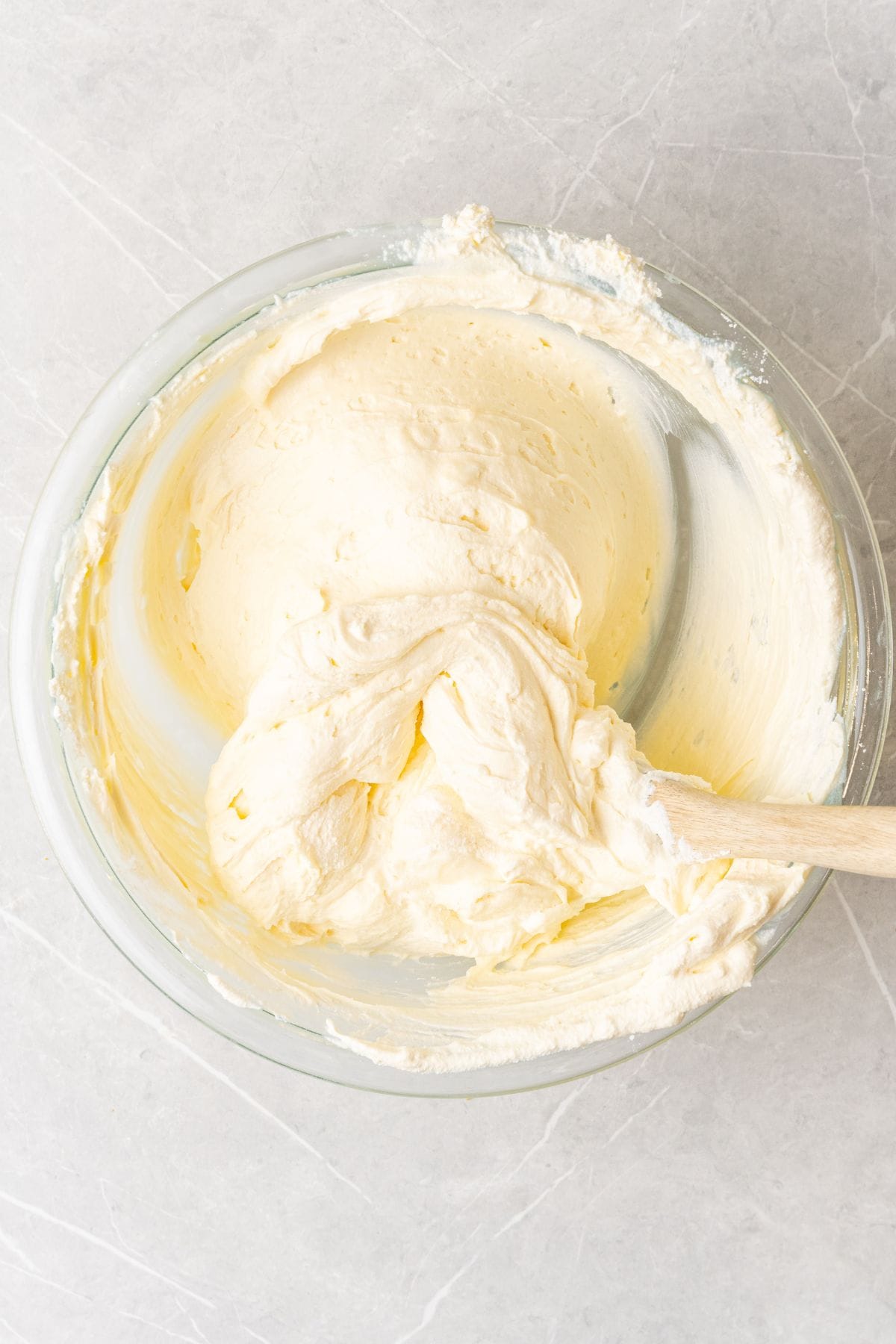 Cheesecake filling with Cool Whip and cream cheese mixed in a bowl.