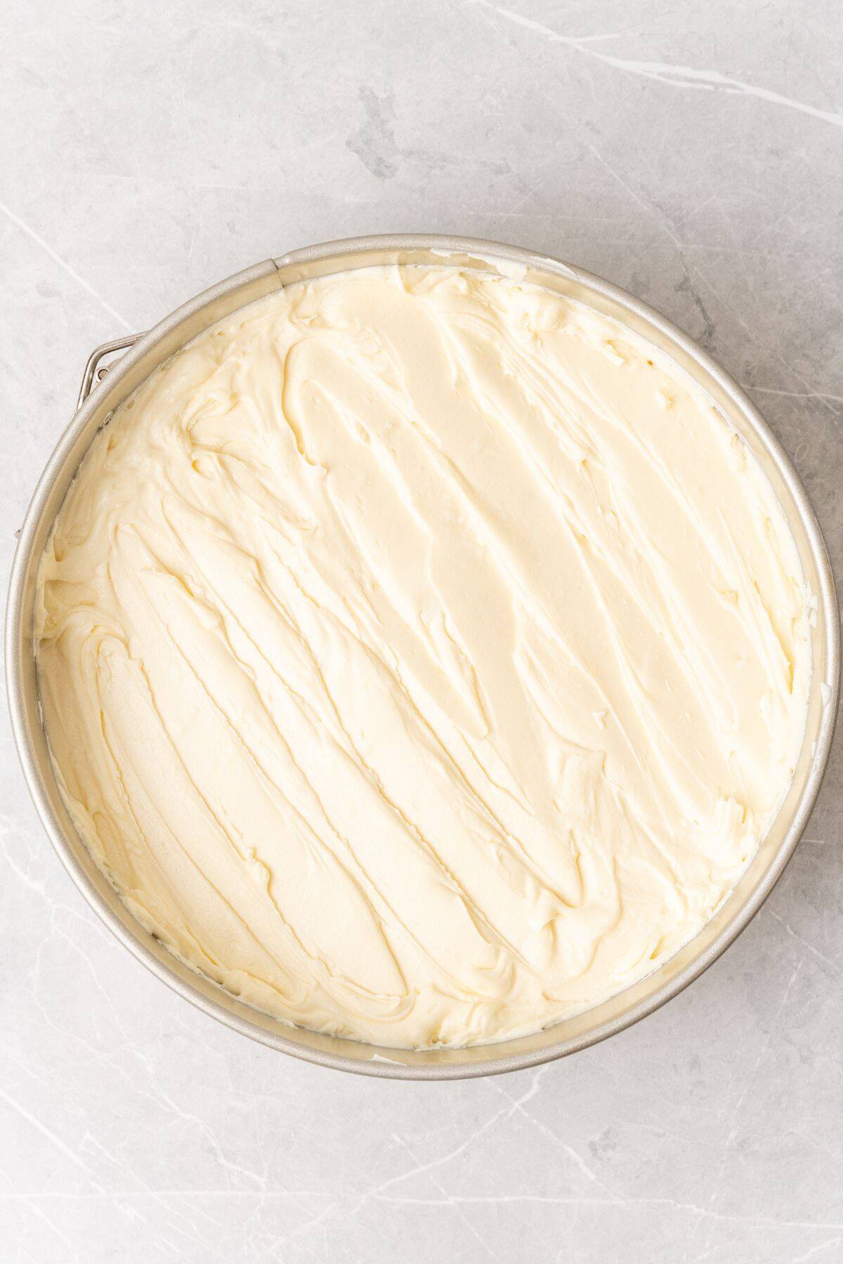 Cool Whip cheesecake spread out in the springform pan ready to be chilled.