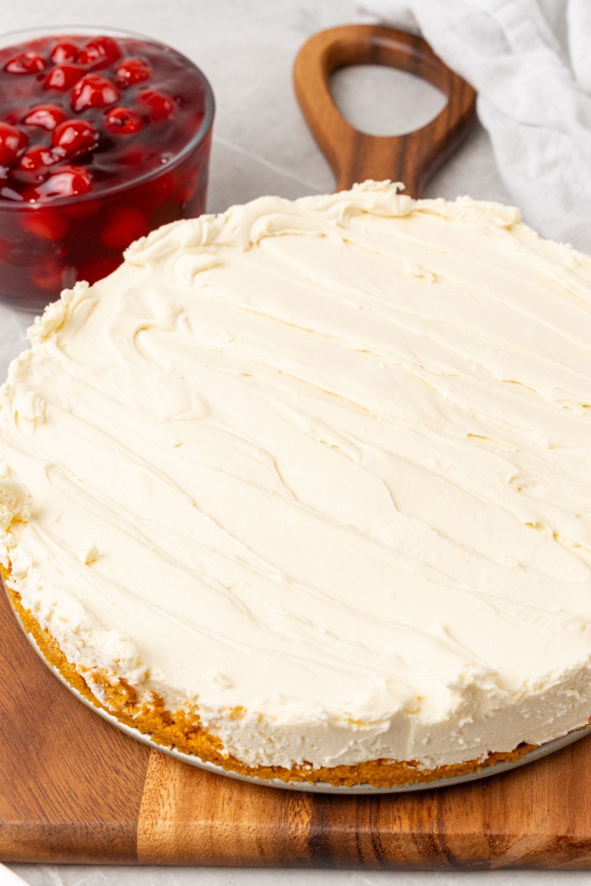 The cheesecake using Cool Whip with the springform sides removed, and before adding the cherry pie filling.