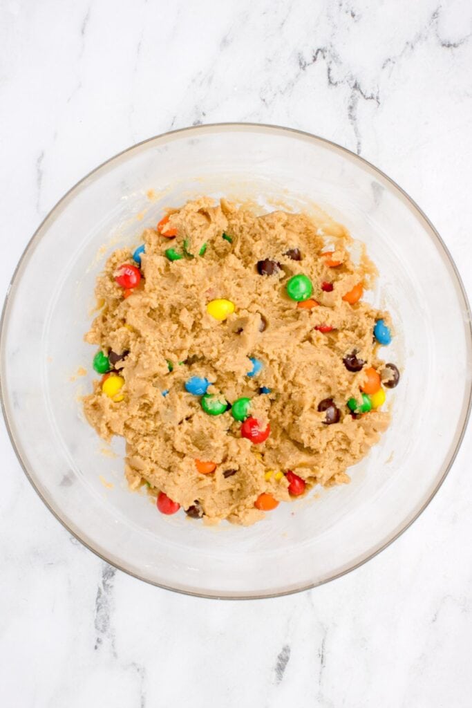Peanut butter cookies with M&Ms dough in a bowl ready to be scooped out.