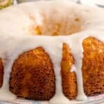 Full view of the pineapple cream cheese pound cake with pineapple glaze dripping on the sides of it.
