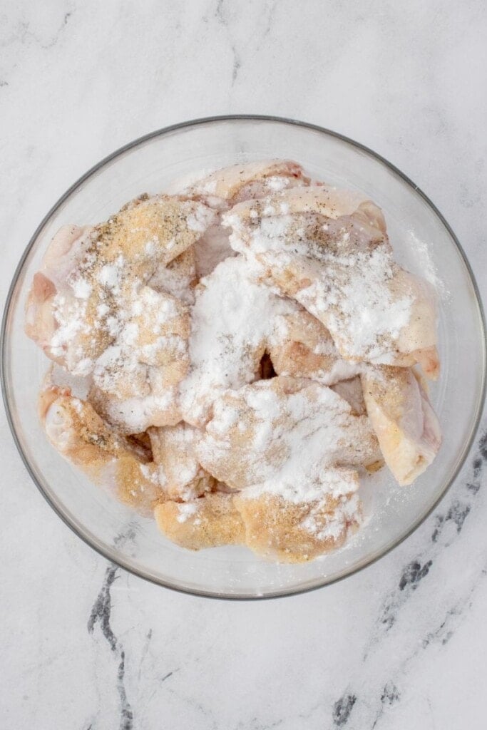 seasoning raw chicken wings with spices and baking powder
