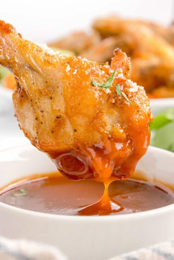 air fried chicken wing dipped into buffalo sauce