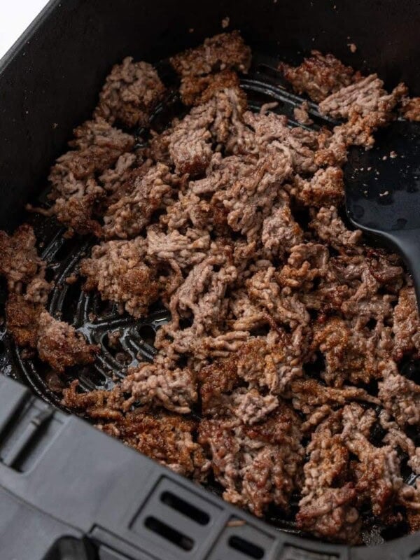 Broken up, browned beef in air fryer basket.