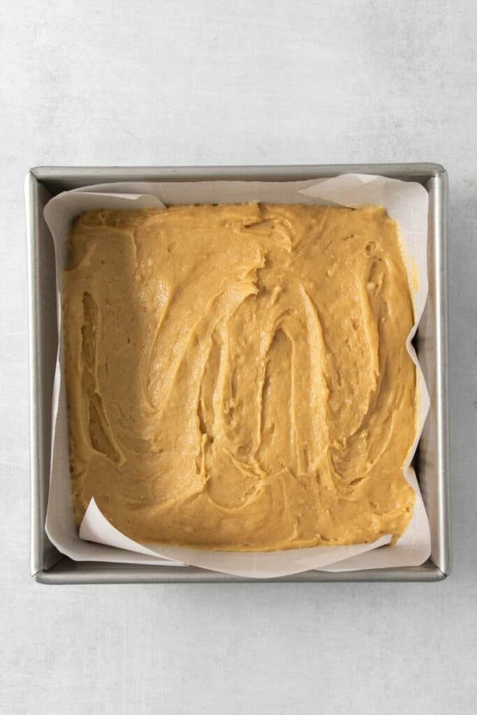 Brownie batter in a lined pan.