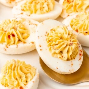 Very close up of the million dollar deviled eggs with a spoon picking one up.