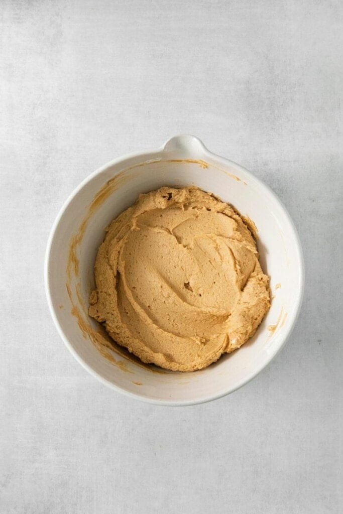 mixing peanut butter, honey, vanilla, cinnamon and greek yogurt in a bowl.