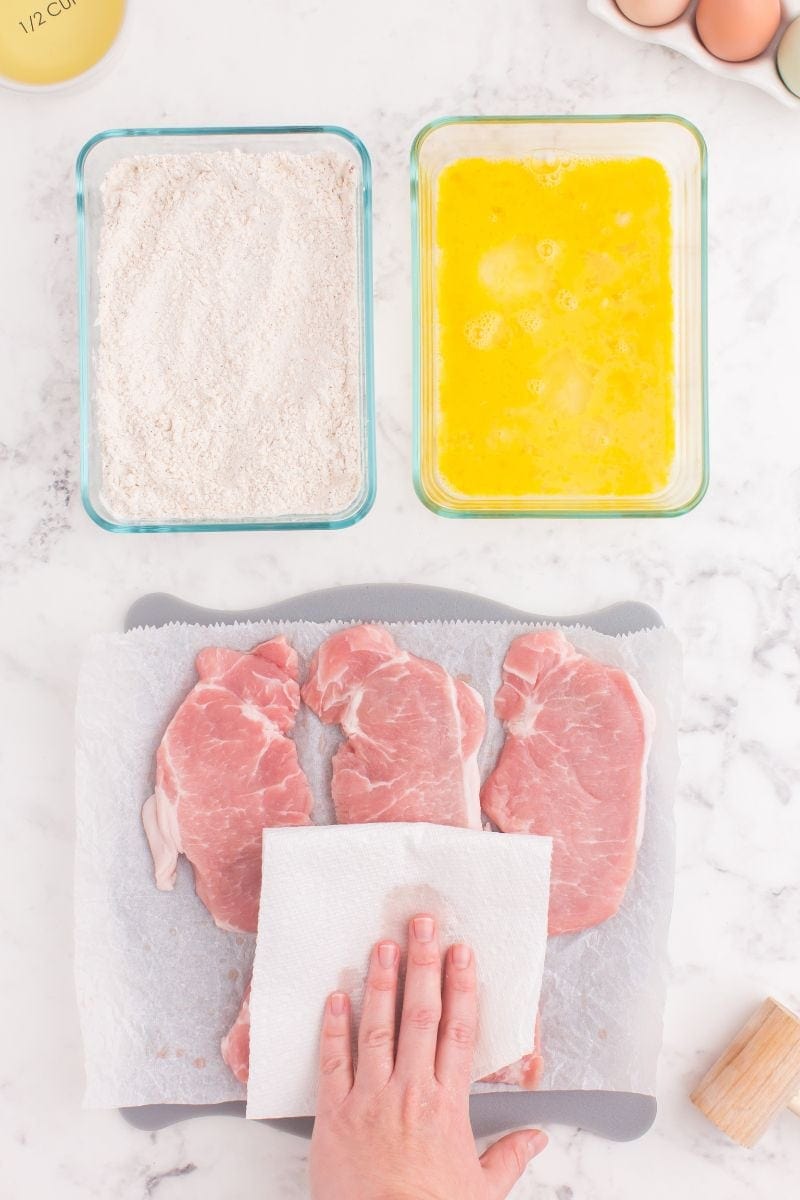 Patting pork chops dry.