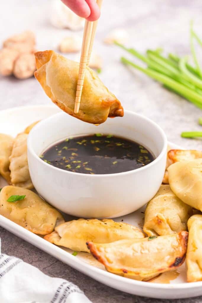 dipping a crispy dumpling into potsticker sauce