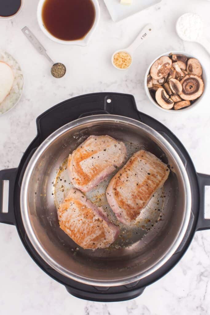 Cooked pork chops in the Instant Pot so they are golden brown on the outside.