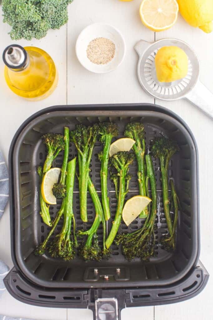 broccolini stalks in an air fryer basket