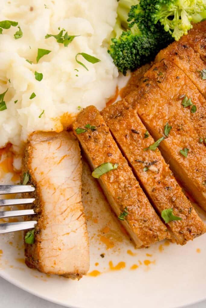 sliced pork chop with potatoes on a plate