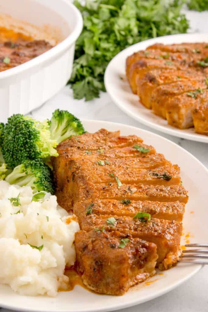 sliced pork chop with mashed potatoes and broccoli