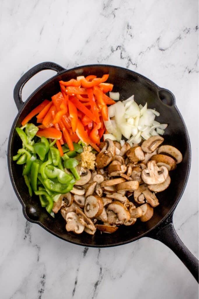 sauteing peppers, onions and mushrooms in pan.