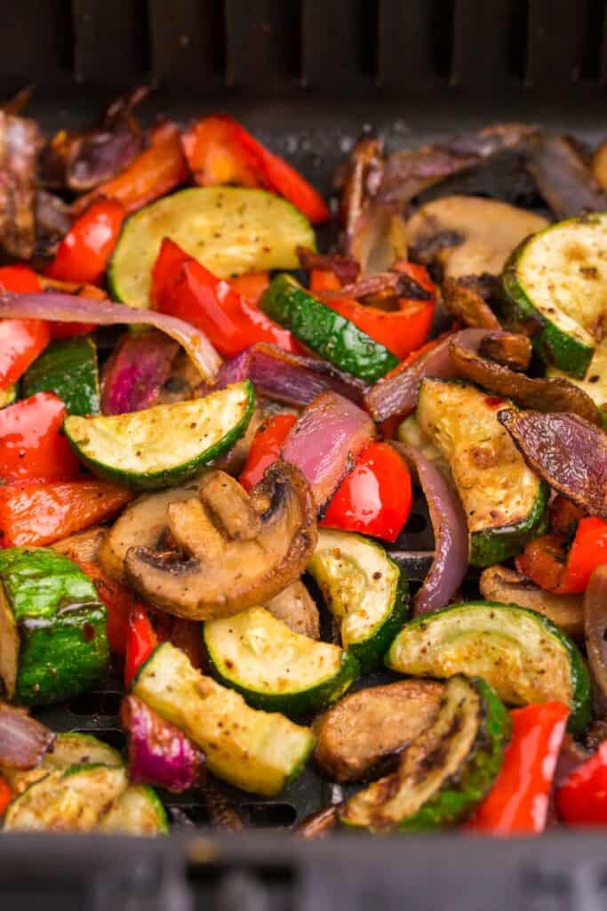 Air fryer vegetables in an air fryer basket.